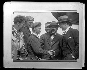 Two men in a group shake hands