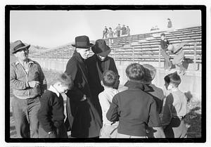 A group of boys gathered by bleachers