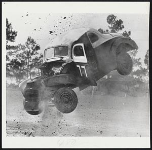 Bucking Horsepower -- This stock car bucked like a bronco when it blew a tire at a stock car race at Jacksonville, Fla. The driver, Warren Davison, came out of the car without a scratch. The machine was a total wreck.