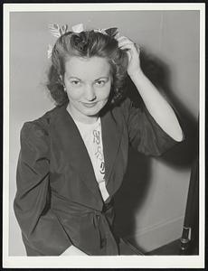 Inventors Display New Gadgets. Non-priority hairpins are the invention of Mrs. Rose Lang, Buffalo, N.Y., housewife. Made of feathers and gaily decorative, they take place of hard-to-get metal hairpins. Miss Lillian Saffran of New York City is trying them out in this picture, taken at the 1942 Inventors' Exposition in New York City, where they were displayed.