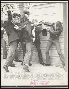 Demonstrators move in on police officer (2d fm R). One (L-C) grabs the officer's helmet, as another jabs at the policeman with a stick, and at extreme L, yet another, a large rock in his hands, tries to brain the officer. Scene was near the Fairmont Hotel, where South Vietnamese Vice President Ky was addressing the Commonwealth Club.