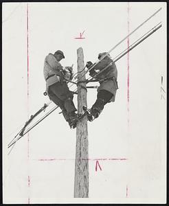 Cold Weather doesn't mean the lineman can sit by the fire. Here are two operating a machine that strengthens the telephone cable by lashing a heavy wire around it.