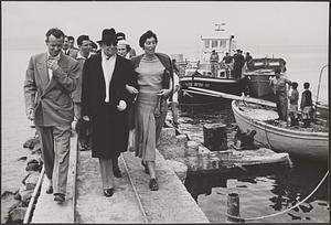 A group of people including Serge Koussevitzky and Olga Koussevitzky walking up a pier