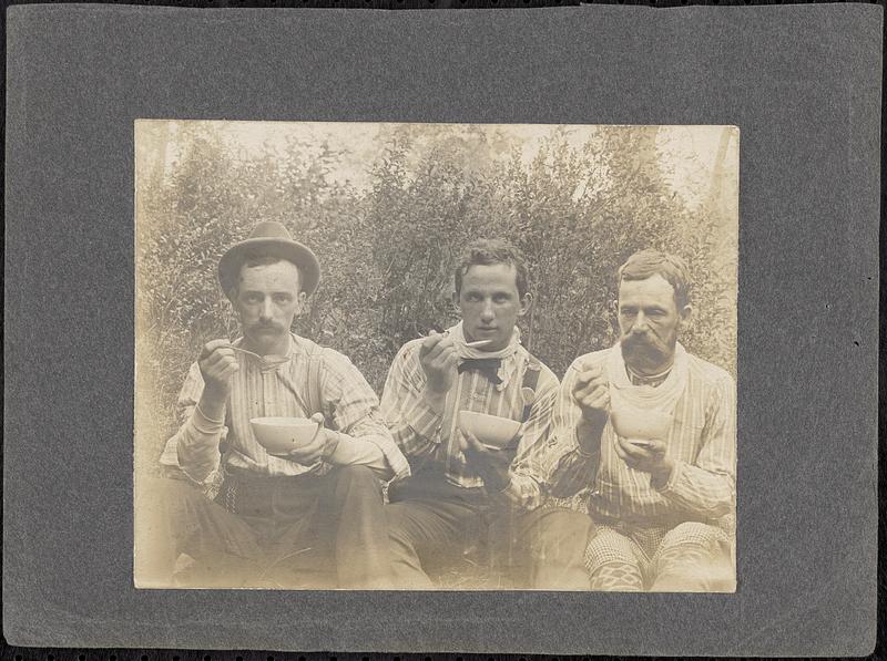 Three men eating outdoors