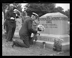 Unidentified man laying flowers at the grave of William T. Cheswell, Boston Fire Department Chief