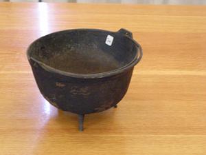 Black metal cauldron with three legs