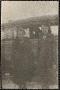 Two women stand next to a vehicle