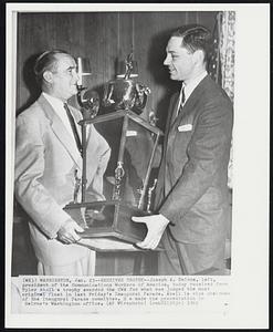 Receives Trophy--Joseph A. Beirne, left, president of the Communications Workers of America, today received from Tyler Abell a trophy awarded the CWA for what was judged the most original float in last Friday's Inaugural Parade. Abell is vice chairman of the Inaugural Parade committee. He made the presentation in Beirne's Washington office.