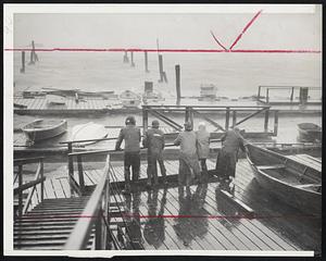 Batten Down-Employes of the Savin Hill Yacht Club move a gangway onto a float after fastening down small boats to floats as heavy rains driven by winds of gale force swept the Boston area.