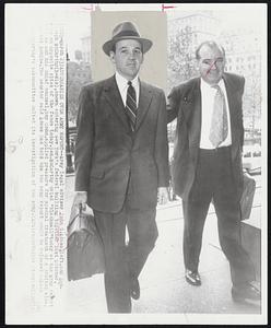 Adversaries over Army Report -- Army legal adviser John G. Adams, left, and Sen. Joseph McCarthy (R-Wis), shown entering New York's federal building together last October, were on opposite sides of the fence today. Sen. McCarthy cried "blackmail" today at the army report that he and his chief counsel, Roy Cohn, applied pressure for special treatment of a drafted aide, David Schine. The senator said Adams had told him the army report would be released unless Sen. McCarthy's subcommittee halted its investigation of the army.