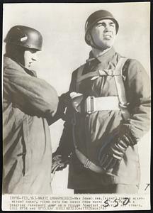 Maxie Unharnessed - Max Schmeling, (right), former heavyweight champ, peers into the skies from where he dropped in a practice parachute jump as a fellow 'chutist unfastens his straps.