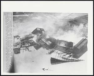 The Earth and the Sea -- A thundering earthquake and a towering tidal wave was responsible for this jumble of burning and wrecked railroad cars in the federally owned Alaska Railroad's railway yard in Seward, Alaska.