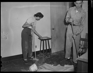 Woman and man sweeping the floor