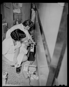 Two women inspecting an electrical appliance