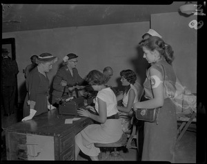 Women at typewriters talking with older women