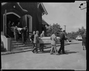 Pallbearers carrying two coffins out of church