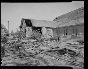 People standing near a building damaged by tornado