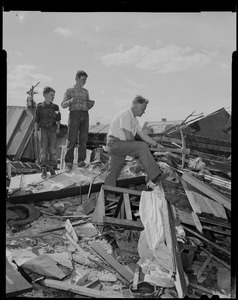 Man and two boys going through wreckage from tornado
