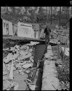 Man standing amid wreckage from tornado