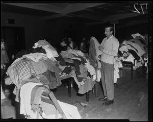 Man going through clothing donation tables