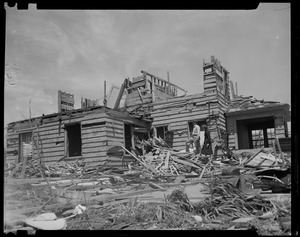 Two people looking at building destroyed by tornado