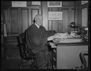 Judge Elijah Adlow sitting at desk, wearing robe