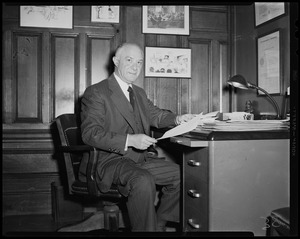 Judge Elijah Adlow sitting at desk, wearing a suit