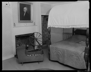 Bedroom with painting above fireplace, bed, crib, and spinning wheel, most likely at Adams National Historical Site