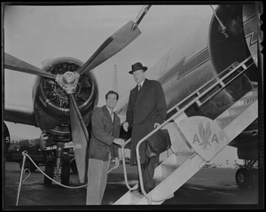 Hugh O'Brien with another man who is descending the airstairs of an American Airlines plane