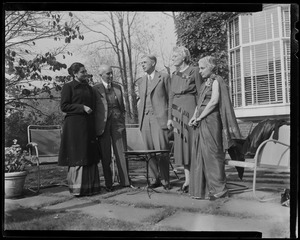 Indira Gandhi, Jawaharlal Nehru, James B. Conant, Mrs. Conant, and Vijaya Lakshmi Pandit standing on patio with outdoor furniture