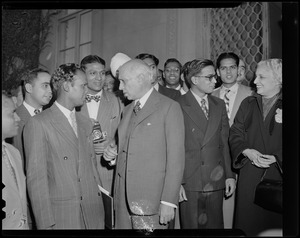 Jawaharlal Nehru, center, and Vijaya Lakshmi Pandit, right, speaking with a group of men, one holding a camera