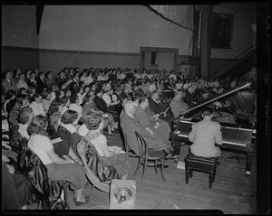 Man seated at piano with audience surrounding him at Billy Graham event