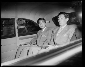 Crown Prince Akihito seated in the backseat of a vehicle with another man