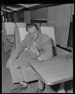 Billy Graham seated at table on train