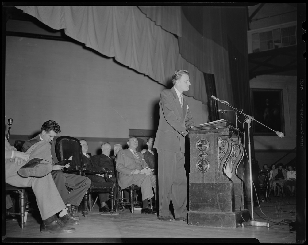 Billy Graham at podium, addressing the crowd