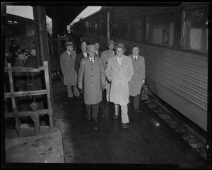Billy Graham walking down train platform with group of men