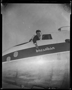 Brendan Behan hanging out of cockpit window of airplane, pointing to Breandán logo