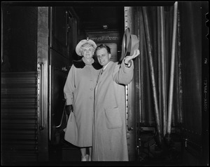 Billy Graham waving hat from steps of train car with his mother, Morrow Coffey Graham