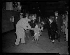 Billy Graham shaking hands with a young boy dressed as a cowboy or sheriff