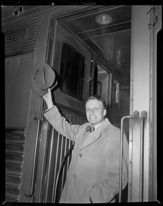 Billy Graham waving hat from steps of train car