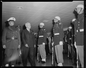 Harry Truman walking by military personnel standing at attention