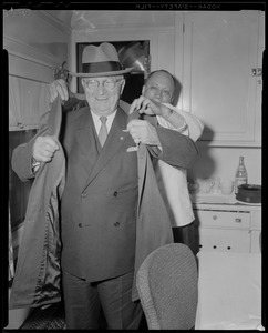 Man helping Harry Truman put on his coat
