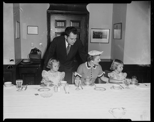 Vice President Richard Nixon leaning over as his wife Pat and daughters Patricia and Julie eat lunch at the table