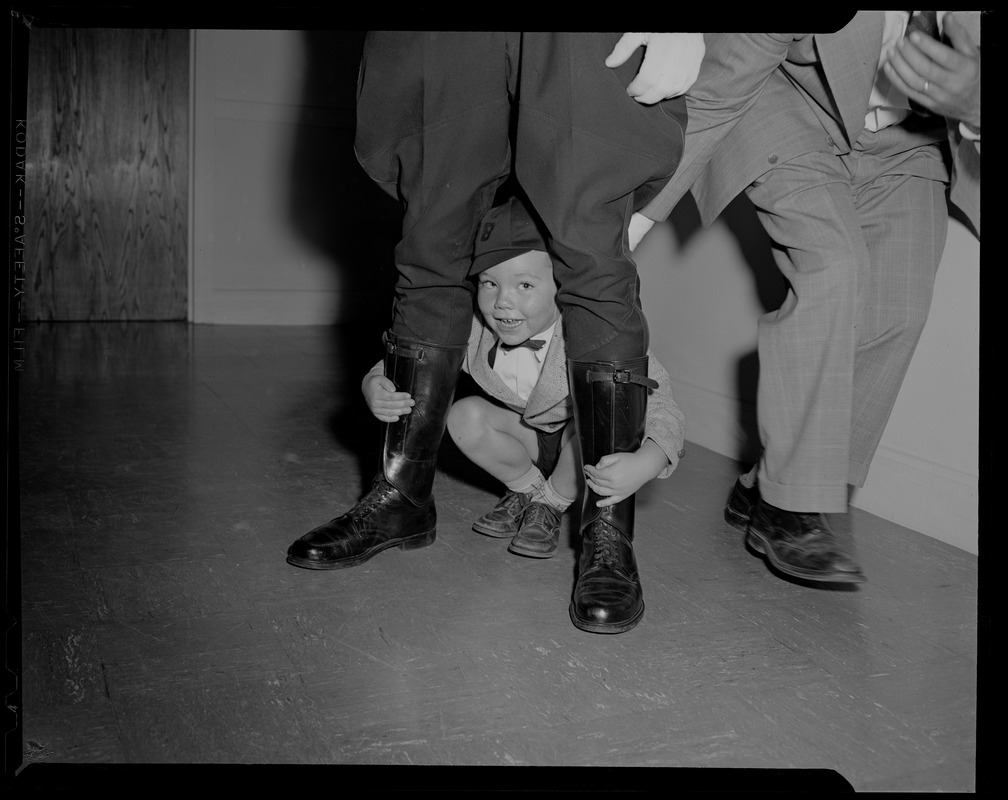 Billy Mark Regan of Lowell comfortably gripped in the "legs of the law" -- and wearing a "beanie" cap -- wears his best smile as he waits for a glimpse of Richard Nixon, Vice President of U.S. at Lowell Tech Institute where Nixon received honorary degree