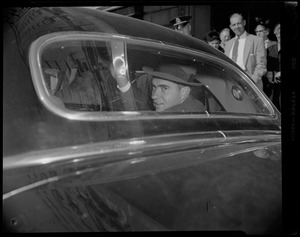 Vice President Richard Nixon waving from back seat of vehicle