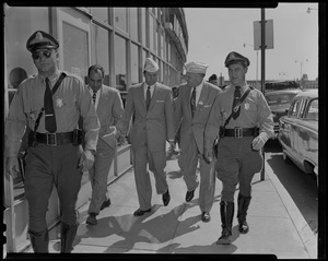Audie Murphy and VFW Commander Merton Tice walking with police officers