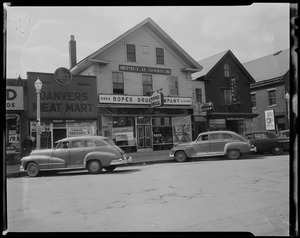 Cars parked outside of Ropes Drug Company store and Danvers Meat Market