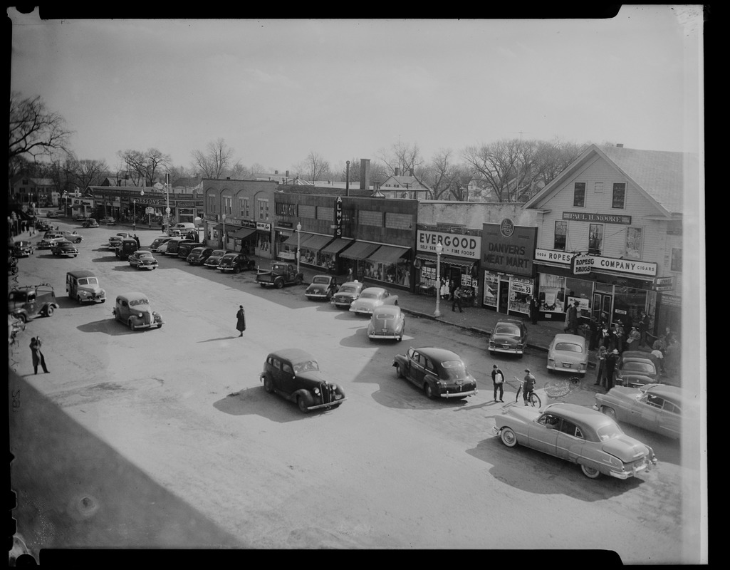 View of cars and stores on Maple Street, including Danvers Meat Market