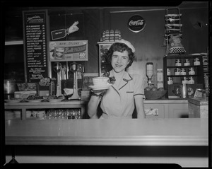 Server Anita Savoie smiling and holding up coffee cup
