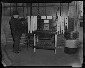 Man standing beside time card machine, most likely in garage
